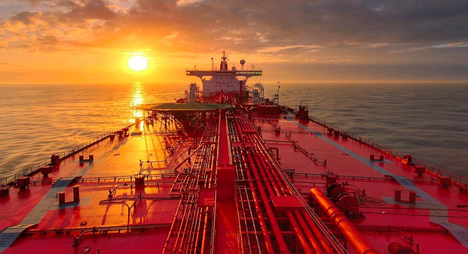 Oil tanker deck at sunset showing pipework and cargo manifolds